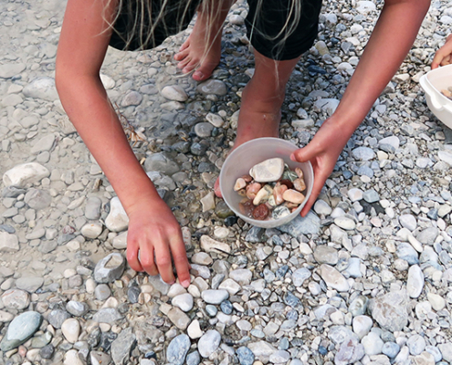 draußen im Sommer mit Kieselsteinen spielen